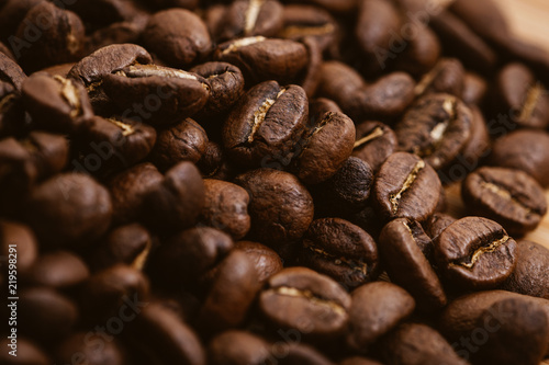 Coffee beans roasted on a wooden table with much of beans with a great aroma