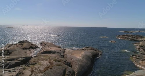 Boat in the archipelago, C4K aerial view of a boat inside a rocky island, on a sunny summer day, in saaristomeri national park, Varsinais-suomi, Finland photo