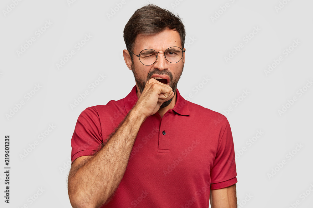 Male worker yawns needs rest, cant wake up early in morning, suffers from insomnia, feels weak and tired, isolated over white background. Exhausted young man feels sleepy. Tiredness concept. Male worker yawns needs rest, cant wake up early in morning, suffers from insomnia, feels weak and tired, isolated over white background. Exhausted young man feels sleepy. Tiredness concept.