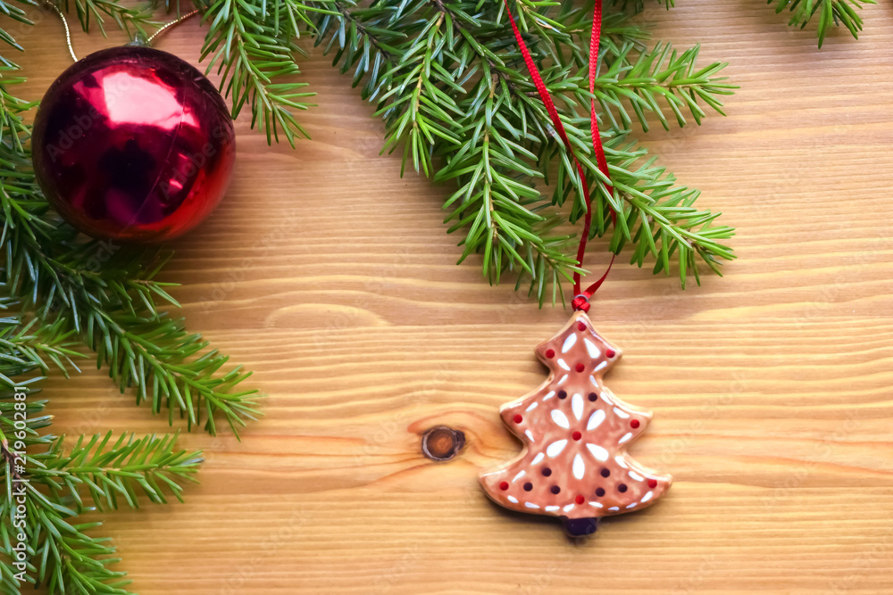 Christmas and New Year composition on a wooden background. A branch of a Christmas tree with an electric garland and Christmas decorations. Concept for a greeting card, poster. Place to insert text. Christmas and New Year composition on a wooden background. A branch of a Christmas tree with an electric garland and Christmas decorations. Concept for a greeting card, poster. Place to insert text.