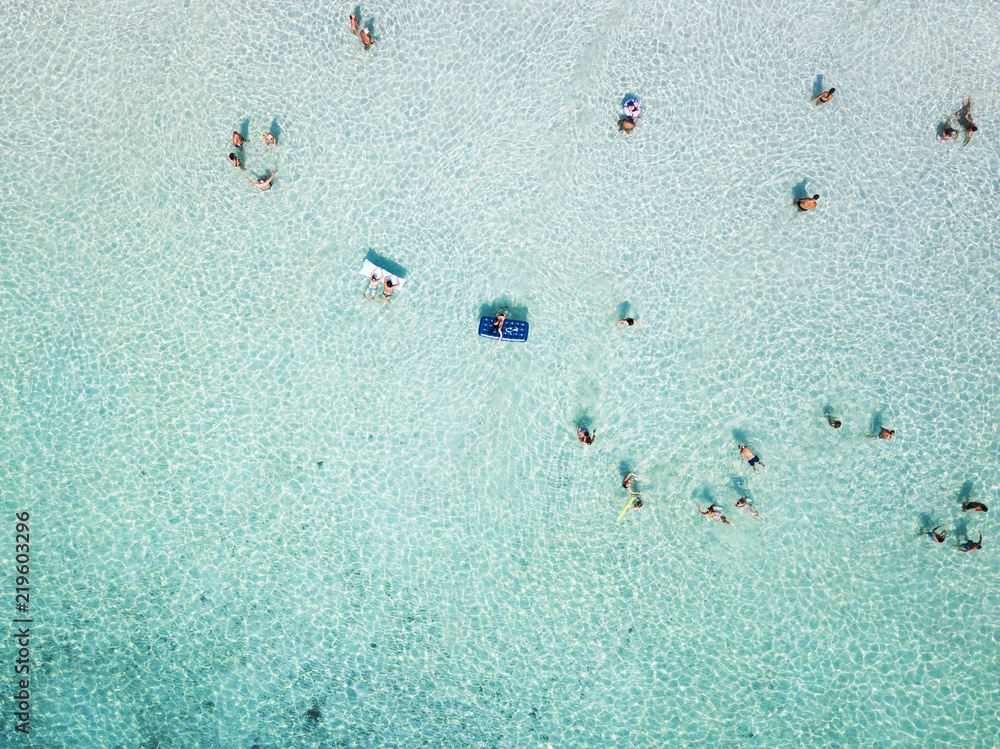 Aerial view of relaxed people swimming on a clear  and transparent sea. Cala Brandinchi, Sardinia, Italy.