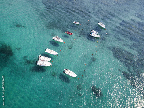 Aerial view of some inflatable boat floating on a beautiful turquoise sea. Sardinia, Italy.