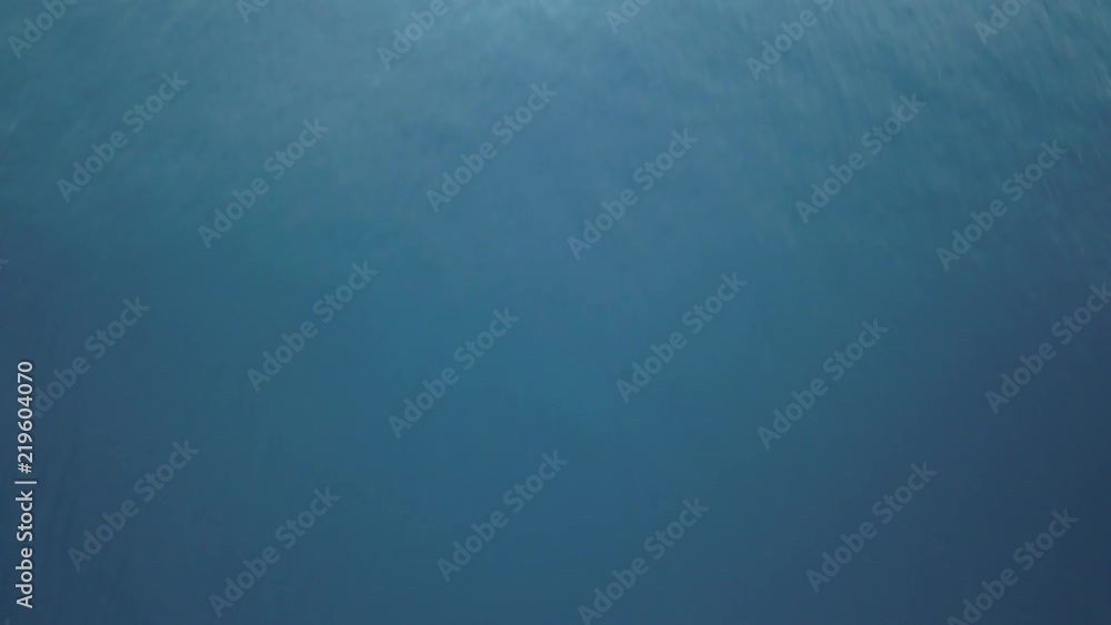 Flight over ocean water, camera tilting up discovering landscape with volcano Agung on background Flight over ocean water, camera tilting up discovering landscape with volcano Agung on background
