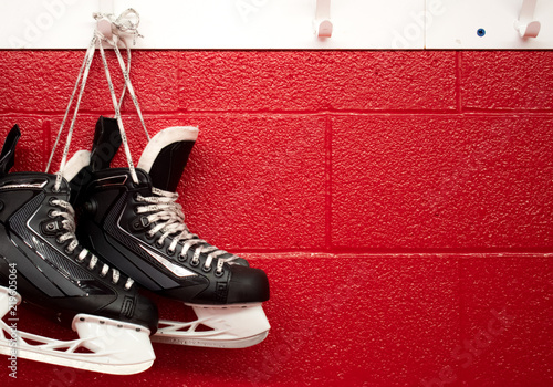 Photography Hockey skates hanging in locker room with copy space in red background