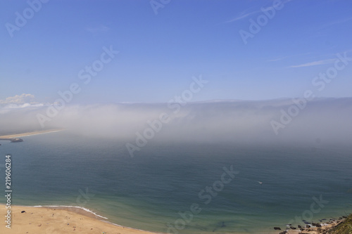 Scenic view of Nazare beach. Coastline of Atlantic ocean. Portuguese seaside town on Silver coast. The clouds above the water are like tsunami waves. Nazare, Portugal.