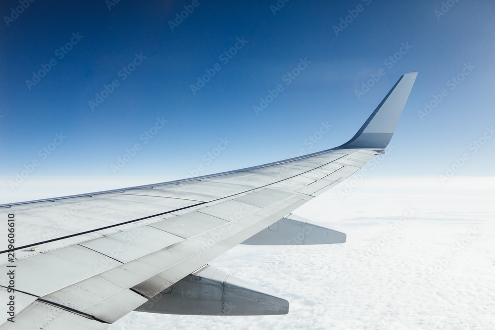 Naklejka premium airplane wing against clouds and blue sky background