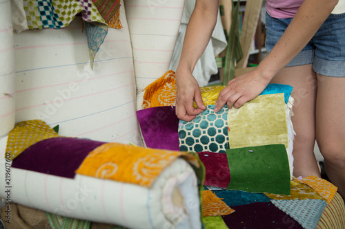 A female tailor stitching velvet pieces for a victorian chair reupholstery, home based business