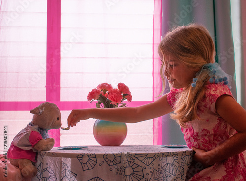 Little Girl Feeding Toy Lamb at Tea Party