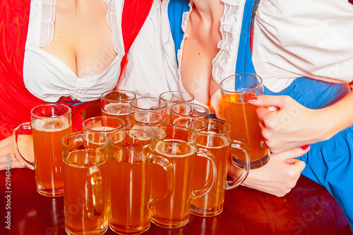 A lot of glasses of beer between the breasts of young girls on the holiday Oktoberfest.