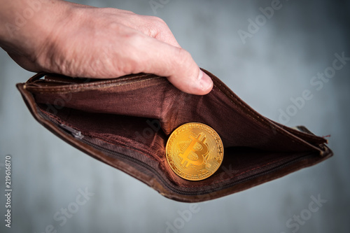 bitcoin coin in the leather brown wallet. e-Commerce concept. Making money on mining. Male hands holding a purse. Male manners and bitcoin photo