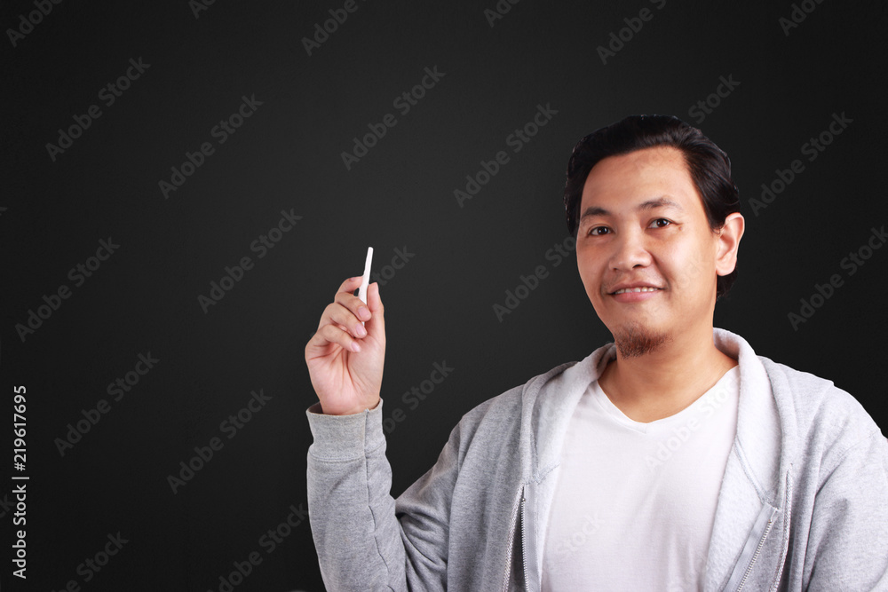 Young Man Holding a Chalk, Smiling Expression Young Man Holding a Chalk, Smiling Expression