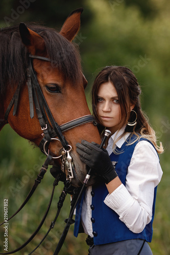 Face of young woman rider equestrian and brown horse touch each other, concept friends.