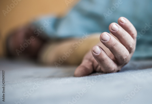 the outstretched arm of a man lying in a bed
