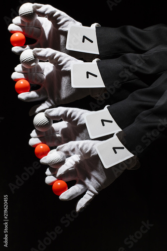 Magician waving his hand. In hand he has a red and white ball. Sleeve is a playing card with the number seven. Photo taken with a long exposure time and used stroboscopic flash. Includes a effect.