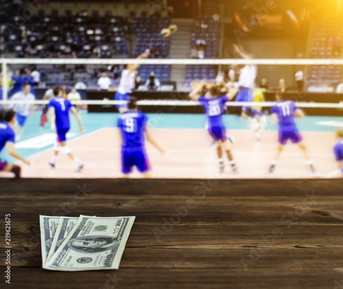 Money dollars on the background of a TV on which show volleyball, sports betting, dollars
