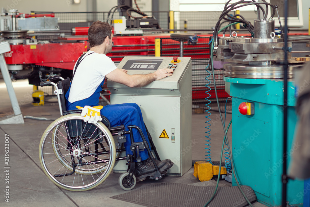 disabled worker in wheelchair in factory and colleague disabled worker in wheelchair in factory and colleague