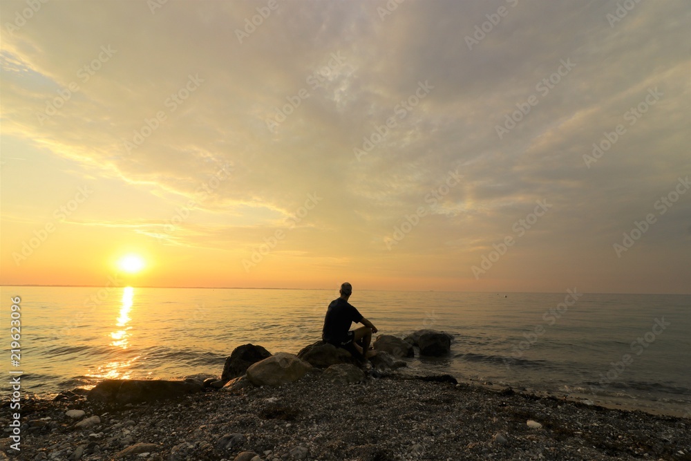 loneley man sitting worried by the sea