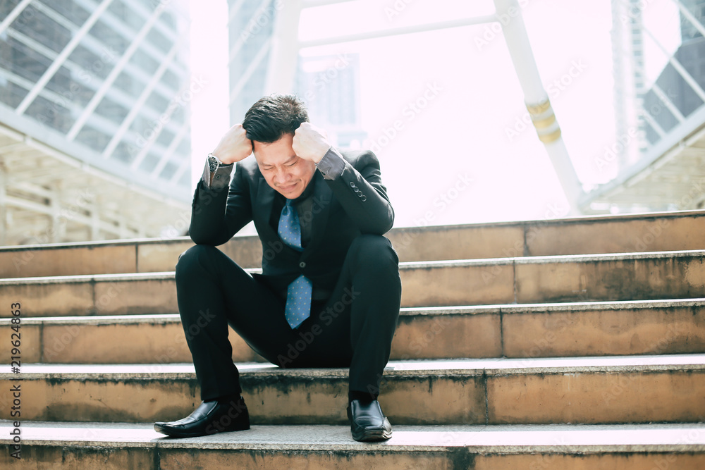 Businessman disappointment of being denied a job, he sat on the steps with hands on head.He felt discouraged and disappointed to find the next job. Businessman disappointment of being denied a job, he sat on the steps with hands on head.He felt discouraged and disappointed to find the next job.