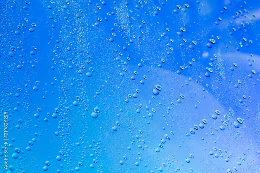 drops of water on the surface of a blue glass