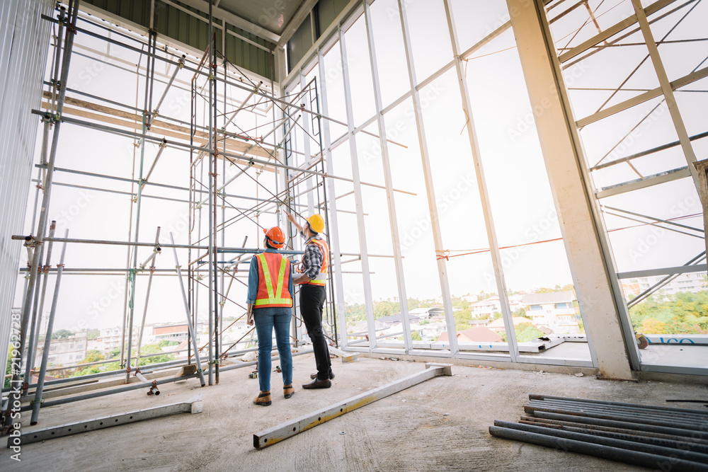 Engineers are meeting and pointed to the plan building in the office to consult a construction tools with security. Engineers are meeting and pointed to the plan building in the office to consult a construction tools with security.