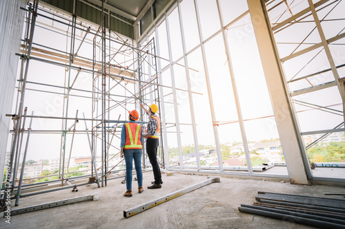 Engineers are meeting and pointed to the plan building in the office to consult a construction tools with security.