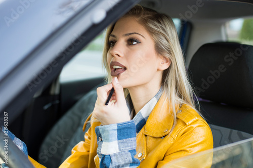 Fotografie beautiful woman doing makeup in the car