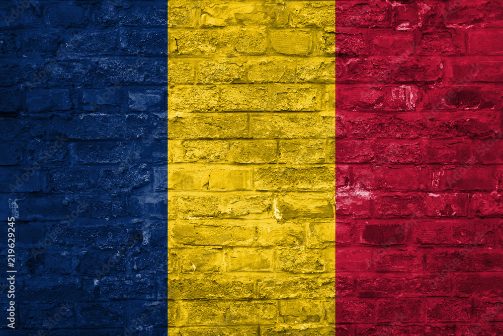 Flag of Chad over an old brick wall background, surface