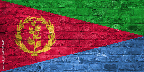 Flag of Eritrea over an old brick wall background, surface
