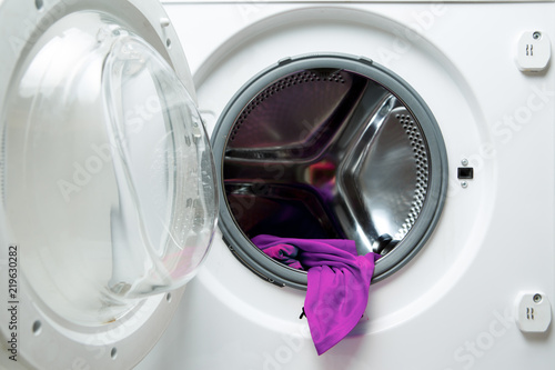 Image of open washing machine with violet cloth © Sergey