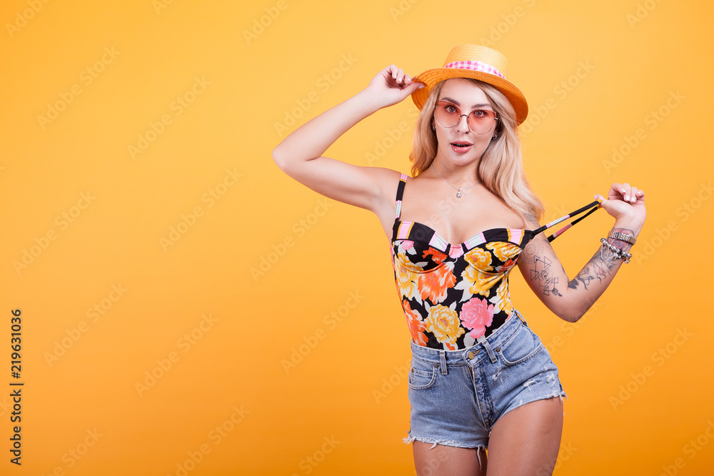 Sexy babe in swimsuit with sunglasses and hat in studio Sexy babe in swimsuit with sunglasses and hat in studio