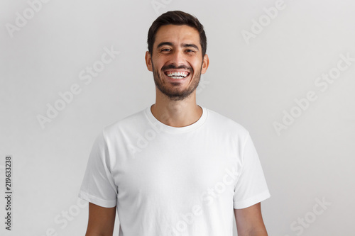 Foto Horizontal shot of young positive european man isolated on gray background stand