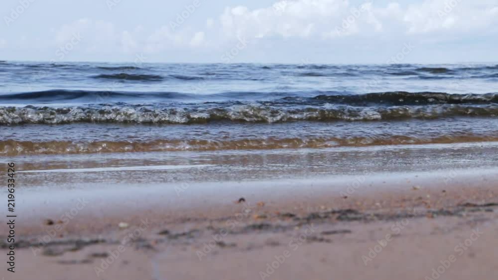 Meditative image of sea waves rolling up on the sand, blue sky, scenic clouds, Low angle shot. Concept of sea, calm, rest and nature infinity. Selective focus. Meditative image of sea waves rolling up on the sand, blue sky, scenic clouds, Low angle shot. Concept of sea, calm, rest and nature infinity. Selective focus.