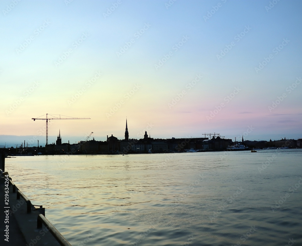 Skyline of Stockholm, capital of Sweden. View of the old city (Gamla Stan). Silhouette of a crane to the left.