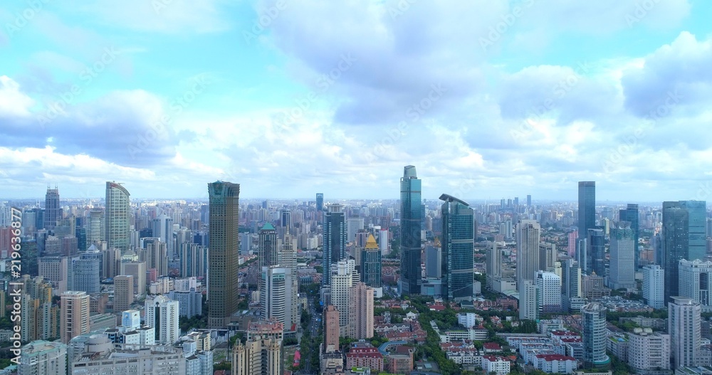 Obraz premium Widok z lotu ptaka na dzielnicę mieszkaniową Szanghaju w pobliżu West Nanjing Road, gęsto zaludniony krajobraz zdominowany przez wieżowce.