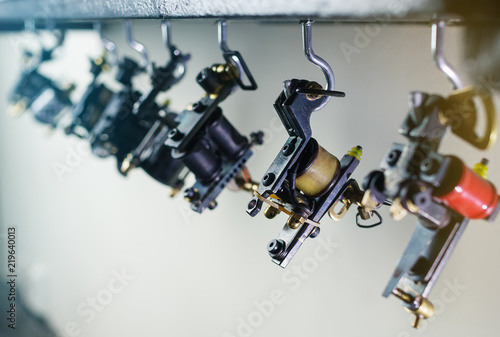 parts of coil ink tattoo machine,  hanging on wooden shelf, close up view