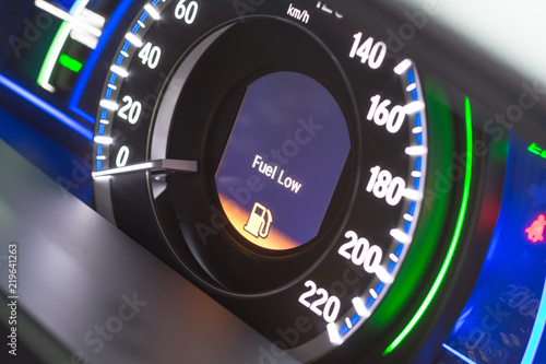 Close up empty Petrol, gasoline gauge dash board in car with digital warning sign of run out of fuel turn on on black background. Low level of fuel show on speedometer dashboard.Odometer Day