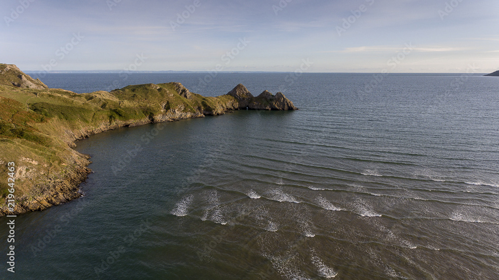 Aerial view of the incoming tide at the dramatic Three Cliffs Bay on the Gower peninsula, Swansea, South Wales, UK
