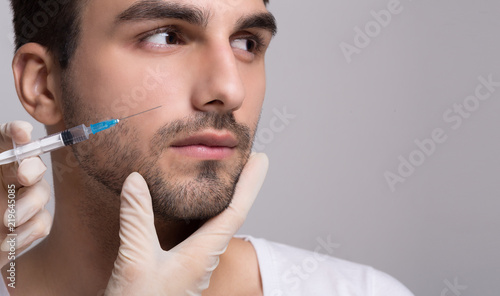 Handsome man receiving injection in his face