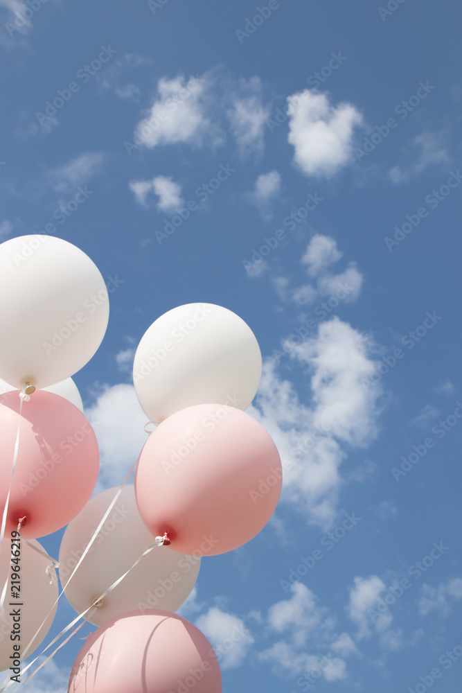 White pink balloons against the sky. Sky with clouds
