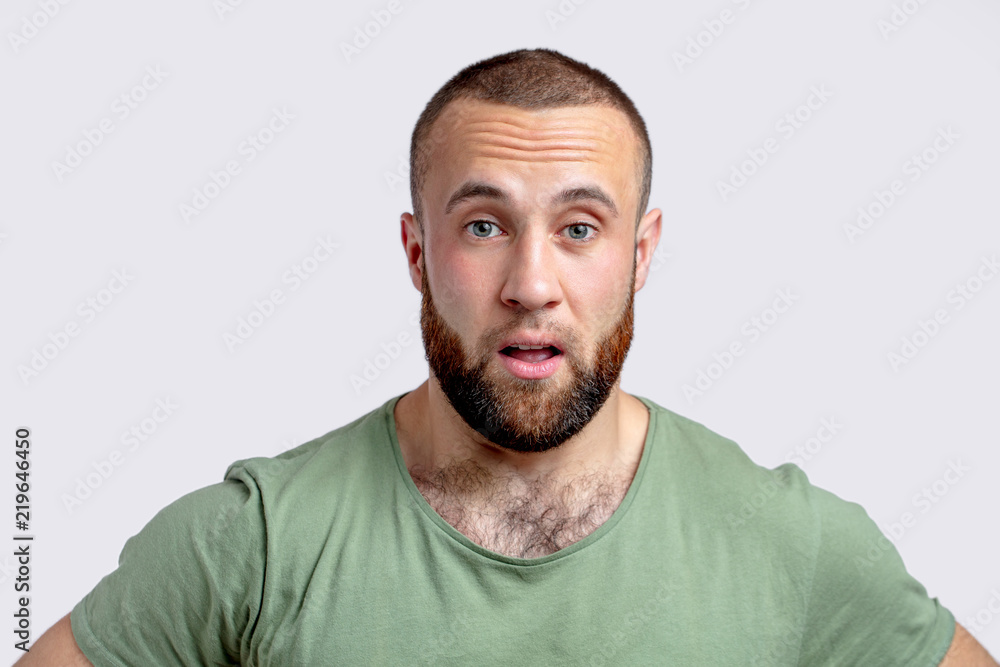 Fototapeta premium Cheerful young man winking over white background