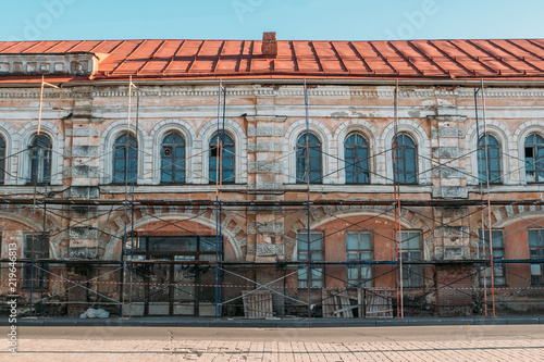 Old building facade exterior restoration or renovation or house reconstruction concept, scaffolding and repair works