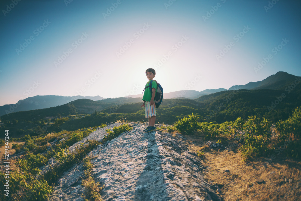 A boy on top of a mountain.