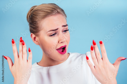 Stampa su tela close-up portrait of nervous unhappy young blonde woman looking at a broken fingernail and crying