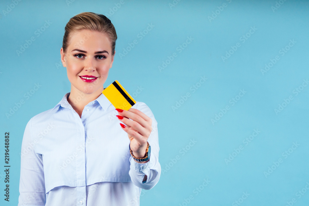 bank employee woman holding golden credit card blue studio portrait. bank employee woman holding golden credit card blue studio portrait.