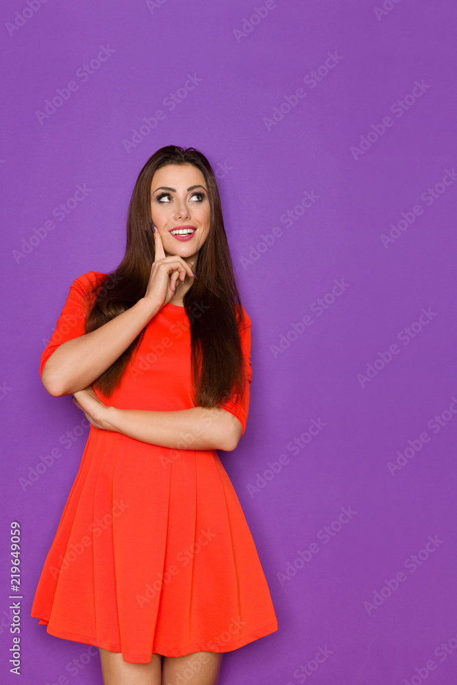Smiling Beautiful Woman In Red Mini Dress Is Thinking And Looking Up Smiling Beautiful Woman In Red Mini Dress Is Thinking And Looking Up