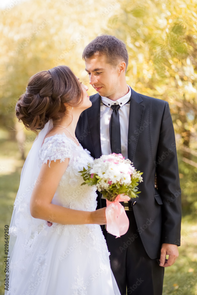 Happy wedding couple. Bride and groom embracing in the park. Sunny autumn day Happy wedding couple. Bride and groom embracing in the park. Sunny autumn day