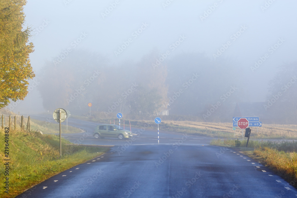 Morning fog at a crossroads on a country road