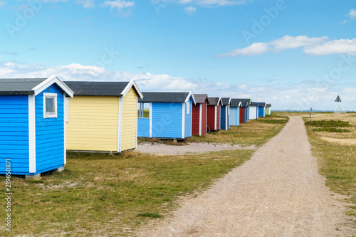 Colorful beach huts along walk path  © Victor