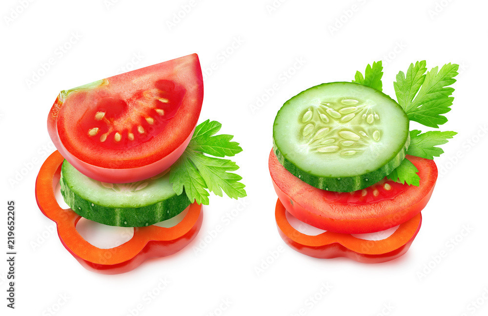 Isolated vegetable pieces. Two images of tomato, cucumber and red bell pepper slices (fresh salad ingredients) on top of each other isolated on white background with clipping path Isolated vegetable pieces. Two images of tomato, cucumber and red bell pepper slices (fresh salad ingredients) on top of each other isolated on white background with clipping path