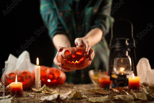 Happy Halloween! Young woman preparing for Halloween in the kitchen. Beautiful woman with pumpkins.